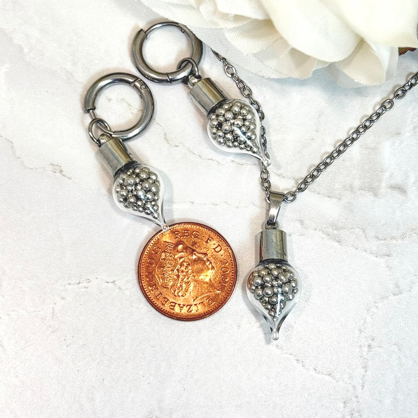 set of jewellery with pendant and huggie earrings filled with pure tin and a british penny for scale