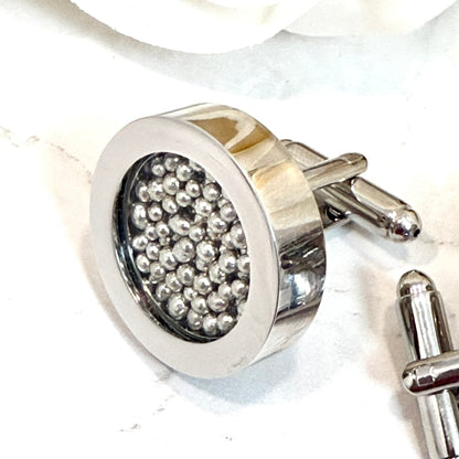 close of a single cufflink showing details of cufflinks filled with pure tin